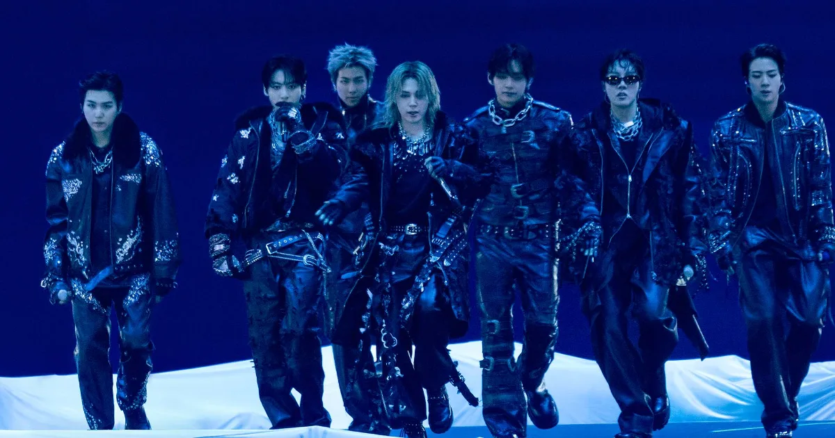 BTS no cinema hoje: os sete integrantes do BTS com figurino escuro da era ARIRANG, em imagem oficial de divulgação